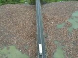 Dezastrul se vede din aer la viaductul Poiana Largului. Lacul este acoperit cu bușteni și gunoaie