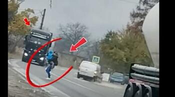 Poliția Română publică o imagine cu o mamă cu copilul în brațe, trecând grăbită printre două TIR-uri