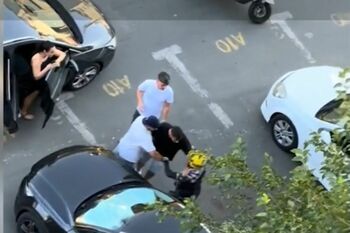 Livrator asiatic pe scuter, înconjurat de trei bărbaţi nervoşi. De la ce a pornit totul
